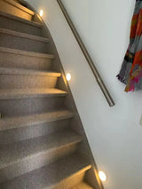 Alt Tag: Motion Sensor LED night light illuminating staircase steps, battery-powered ABS wall lights for safe hallway and stairs